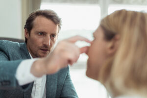 Le chirurgien Dr Koppe analyse le visage d'une patiente femme mature.  